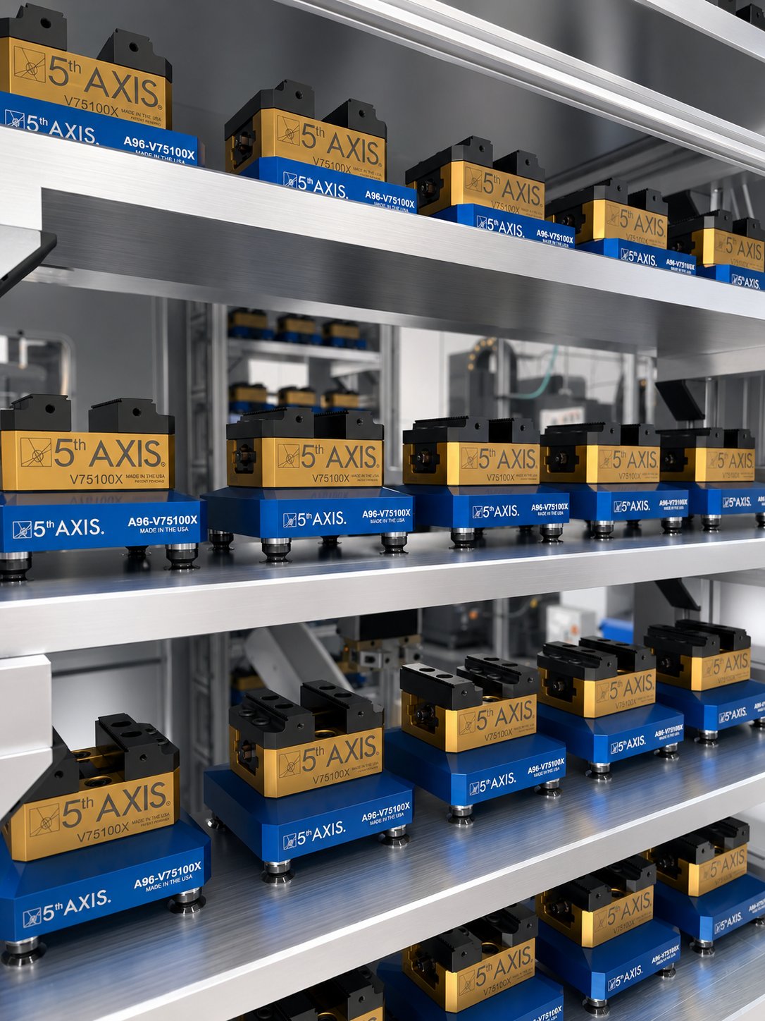 Rows of identical 5th Axis V75100X vises on staging shelves, demonstrating standardized automation hardware at scale